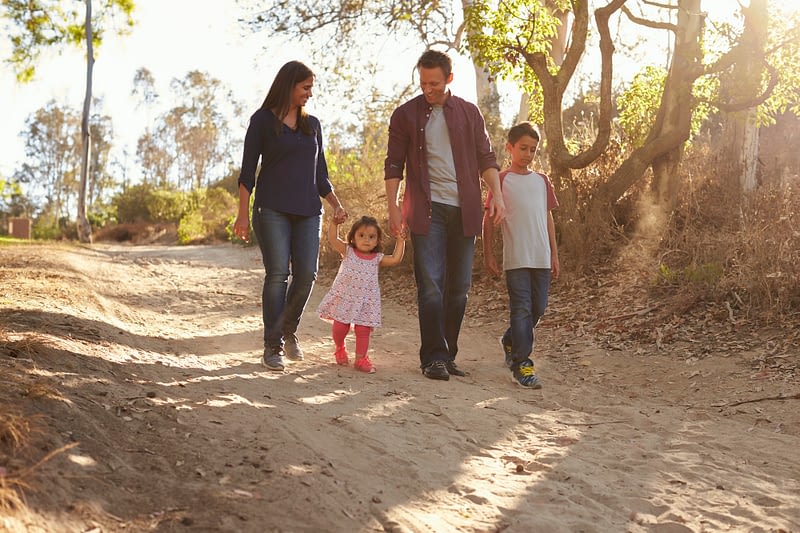 Mixed race family walking on rural path, front view