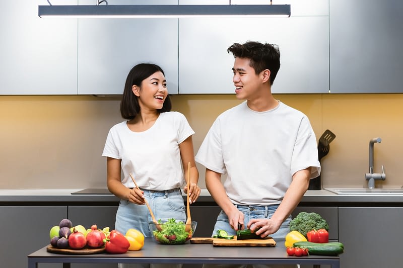 Loving Asian Couple Cooking Healthy Food In Kitchen At Home